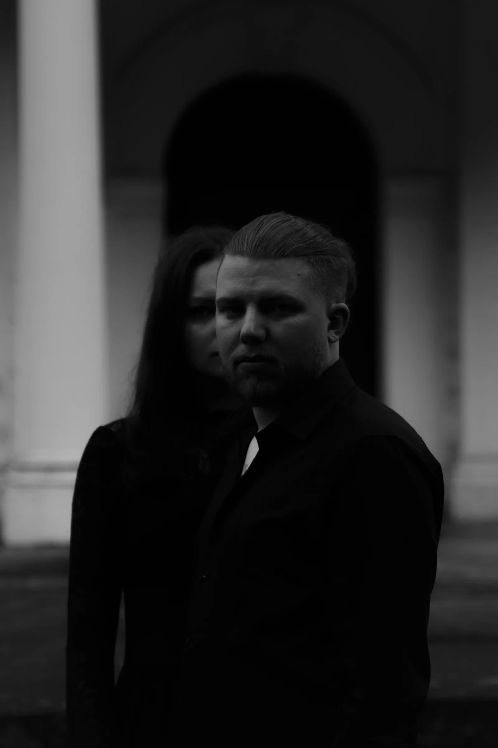 Portret pary w czerni, czarno-biały, na tle jasnej ściany