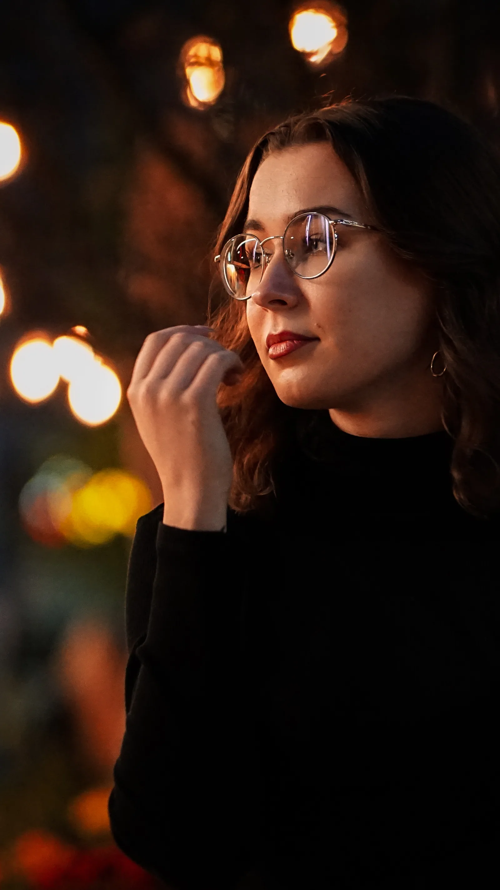 Portret kobiety w okularach na tle rozmytych świateł miasta